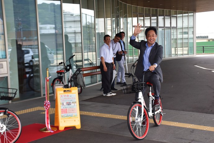 写真：自転車に乗って手をふる市長